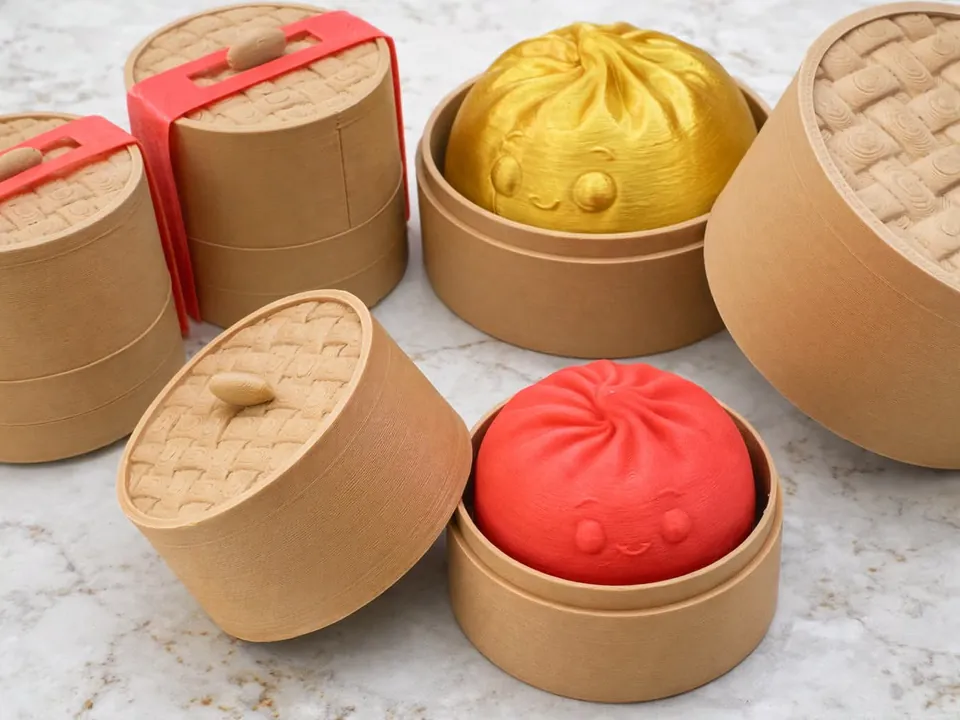 Tiny steamer baskets holding red and yellow dumpling clickers