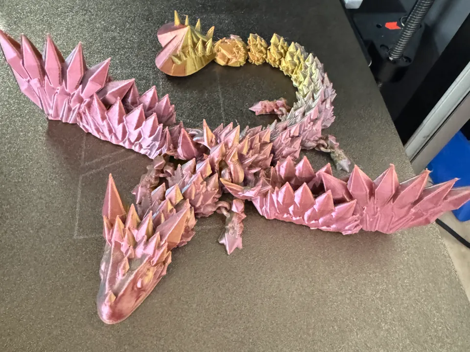 Pink and gold baby crystal wing dragon with a heart-shaped tail