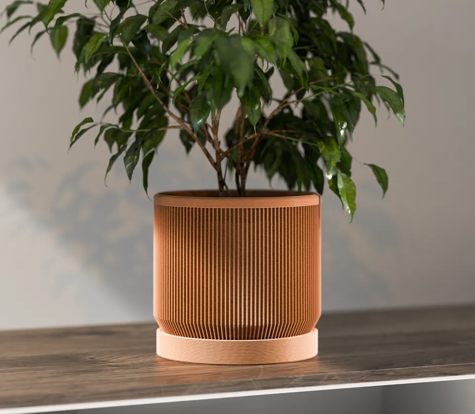 Terracotta-colored ribbed planter with a drip tray holding a leafy plant