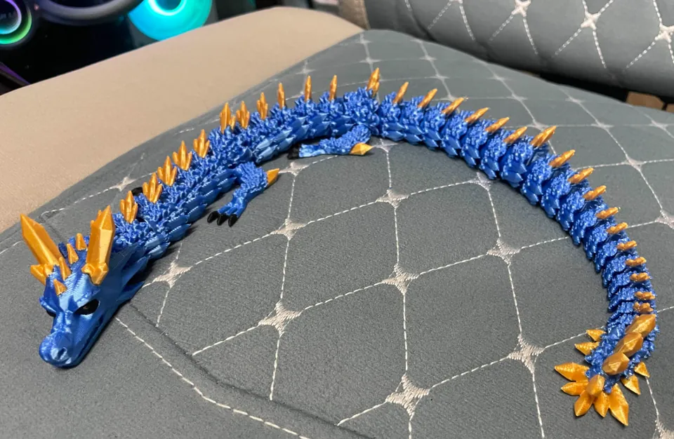 Long blue and gold articulated crystal dragon on a couch