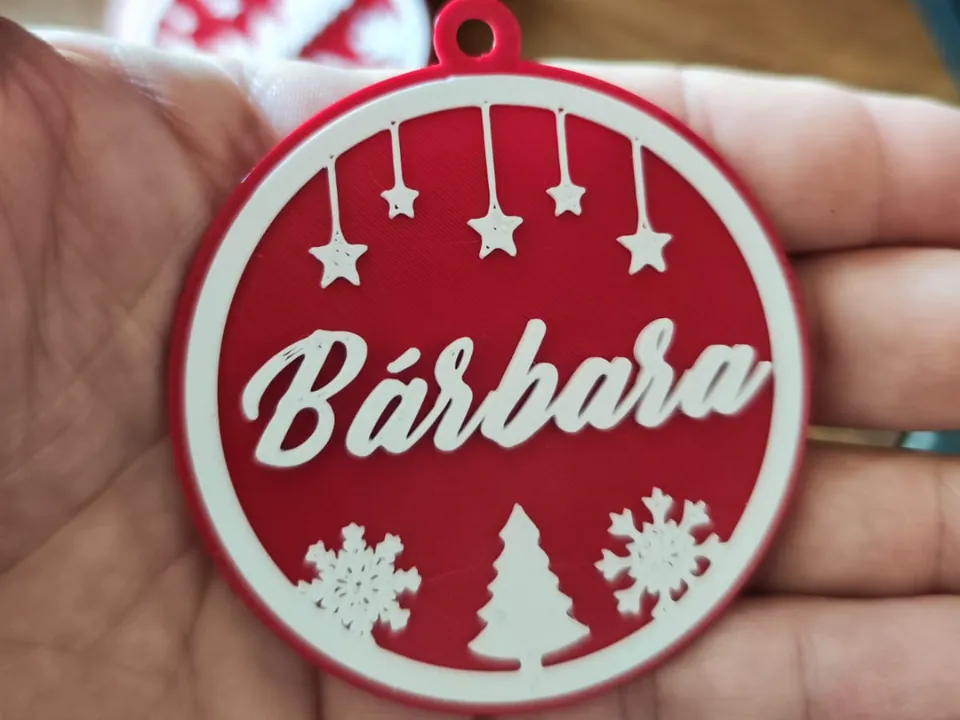 Red and white round Christmas ornament with a name across the middle