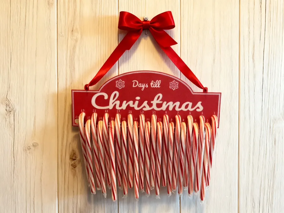 Red 'Days till Christmas' sign with candy canes hanging below it